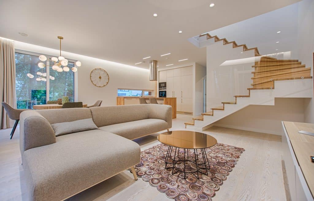 open-plan living room with round coffee table and sofa with stairs leading up to another level