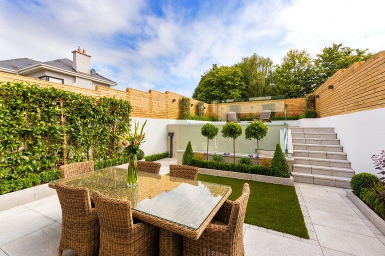 set of outdoor wicker furniture on a patio with grass in the background