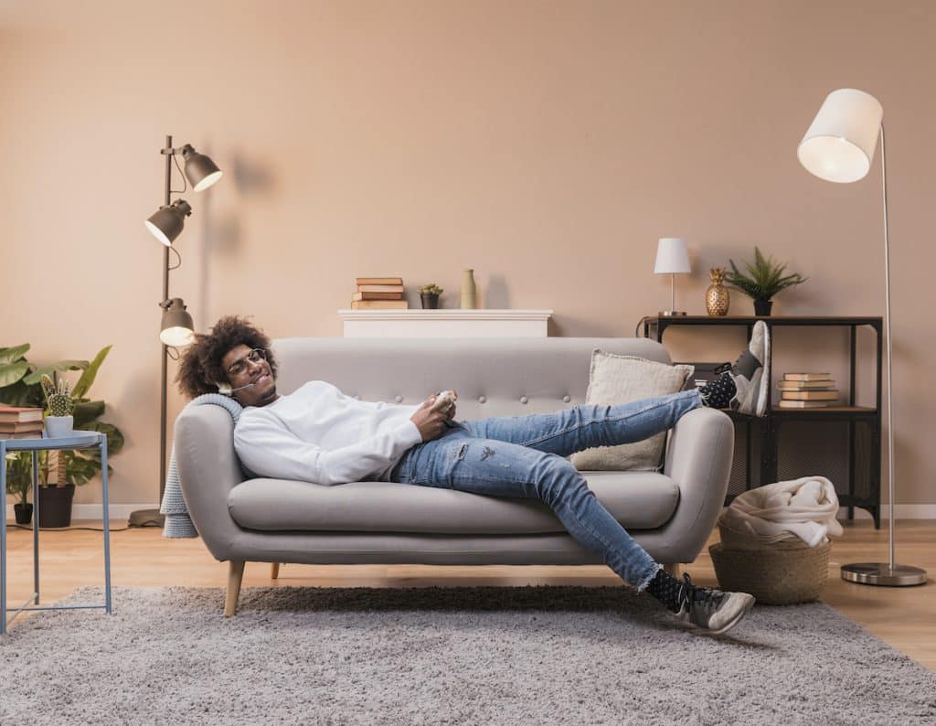 photo male laid on couch playing games