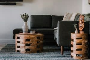round wooden coffee table and grey sofa