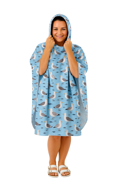 Woman smiling in a seagull-patterned hooded poncho.